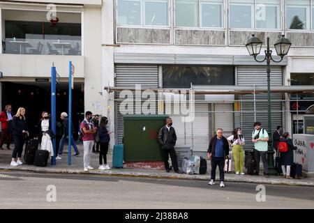 Menschen warten auf den Bus an einer Bushaltestelle in Athen Griechenland Stockfoto