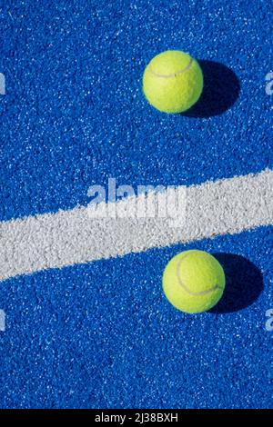 Selektive Fokussierung von zwei Paddle-Tennisbällen auf einem blauen Paddle-Tennisplatz, Schlägersportkonzept Stockfoto