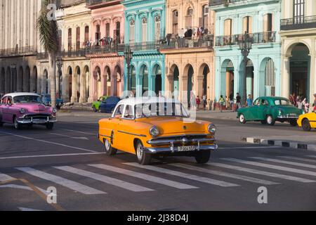 Alte amerikanische Oldtimer fahren an alten pastellfarbenen Gebäuden am Paseo de Mart’ in Havanna, Kuba vorbei Stockfoto