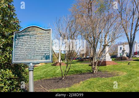 FORT MILL, S.C.-2. APRIL 22: Informationsschild zum Confederate City Park, mit Denkmälern im Park dahinter. Stockfoto