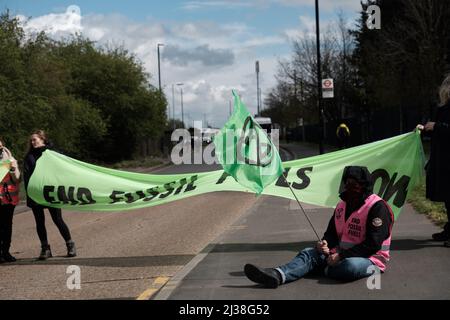 Staines, Großbritannien. 6. April 2022. Mitglieder des Extinction Rebellion besteigen die Tanker am Eingang zum Esso West London Terminal in der Nähe des Flughafens Heathrow. Die Demonstranten fordern ein Ende der fossilen Brennstoffe. Extinction Rebellion (XR) und Just Stop Oil blockieren seit dem Wochenende Straßen, die für den Zugang zu Ölraffinerien in der Nähe von London und Birmingham genutzt wurden, und verhindern, dass Tankwagen die Treibstoffdepots verlassen oder betreten. Stockfoto