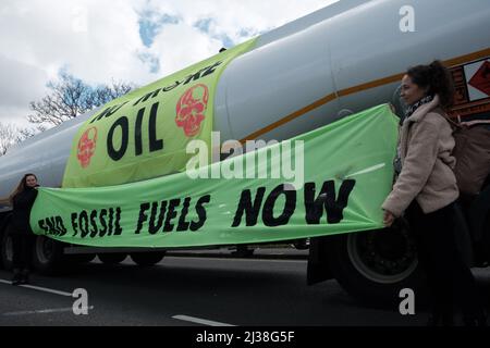 Staines, Großbritannien. 6. April 2022. Mitglieder des Extinction Rebellion besteigen die Tanker am Eingang zum Esso West London Terminal in der Nähe des Flughafens Heathrow. Die Demonstranten fordern ein Ende der fossilen Brennstoffe. Extinction Rebellion (XR) und Just Stop Oil blockieren seit dem Wochenende Straßen, die für den Zugang zu Ölraffinerien in der Nähe von London und Birmingham genutzt wurden, und verhindern, dass Tankwagen die Treibstoffdepots verlassen oder betreten. Stockfoto