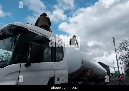 Staines, Großbritannien. 6. April 2022. Mitglieder des Extinction Rebellion besteigen die Tanker am Eingang zum Esso West London Terminal in der Nähe des Flughafens Heathrow. Die Demonstranten fordern ein Ende der fossilen Brennstoffe. Extinction Rebellion (XR) und Just Stop Oil blockieren seit dem Wochenende Straßen, die für den Zugang zu Ölraffinerien in der Nähe von London und Birmingham genutzt wurden, und verhindern, dass Tankwagen die Treibstoffdepots verlassen oder betreten. Stockfoto