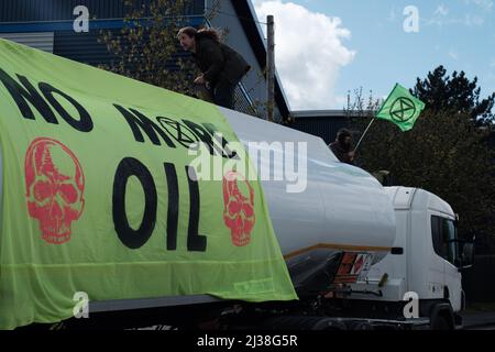 Staines, Großbritannien. 6. April 2022. Mitglieder des Extinction Rebellion besteigen die Tanker am Eingang zum Esso West London Terminal in der Nähe des Flughafens Heathrow. Die Demonstranten fordern ein Ende der fossilen Brennstoffe. Extinction Rebellion (XR) und Just Stop Oil blockieren seit dem Wochenende Straßen, die für den Zugang zu Ölraffinerien in der Nähe von London und Birmingham genutzt wurden, und verhindern, dass Tankwagen die Treibstoffdepots verlassen oder betreten. Stockfoto