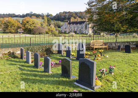 Blick über den Kirchhof von St Mary the Virgin in Richtung Flaxley Abbey im Dorf Forest of Dean in Flaxley, Gloucestershire, England Stockfoto