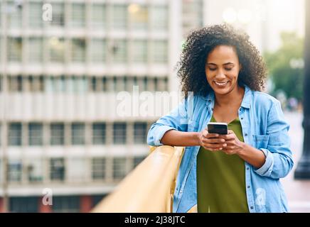 Dies ist der Ort, an dem sich gut treffen. Aufnahme einer jungen Frau, die ihr Handy benutzte, während sie in der Stadt unterwegs war. Stockfoto