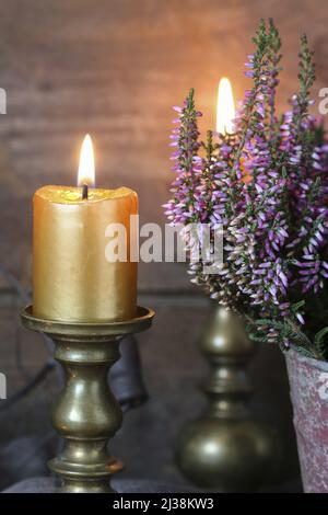 Heidekraut (Calluna vulgaris) im Vintage-Eimer und einer Kerze. Einrichtung im Herbst Stockfoto