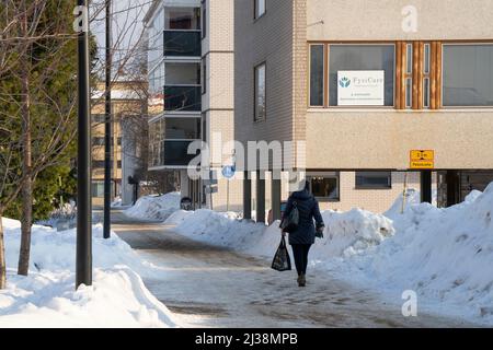 Rovaniemi, Finnland - 17.. März 2022: Ein Spaziergang auf einer verschneiten Straße in Rovaniemi, Finnland. Stockfoto