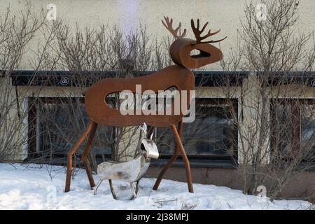 Rovaniemi, Finnland - 17.. März 2022: Zwei Rentierskulpturen aus Metall auf einer Straße in Rovaniemi, Finnland, an einem Wintertag. Stockfoto