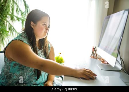 Porträt der Trisomie 21 Erwachsene arbeiten am Computer Stockfoto