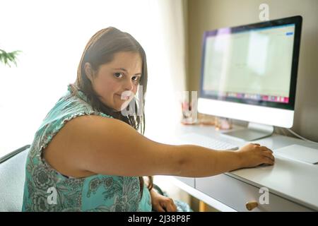 Porträt der Trisomie 21 Erwachsene arbeiten am Computer Stockfoto