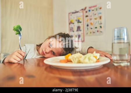 Ihr könnt mich nicht dazu bringen, dies zu essen. Aufnahme eines kleinen Mädchens, das sich weigert, ihren Brokkoli zu essen. Stockfoto