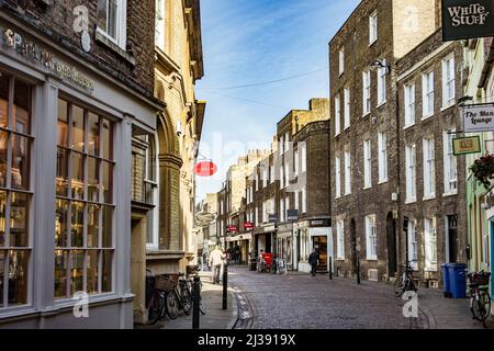 CAMBRIDGE, ENGLAND - 13. MÄRZ 2017: Typische Straßenszene in der Altstadt von Cambridge. Die Straßen sind immer noch mit Kopfsteinpflaster bedeckt. Stockfoto