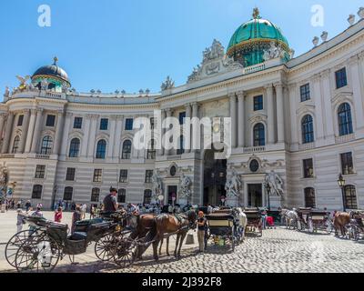 WIEN, ÖSTERREICH - 28. MAI 2017: Traditioneller Kutscher und zwei geschmückte Pferde, genannt Fiaker, warten auf Touristen in der Wiener Hauptstraße, der "Neustadt" Stockfoto