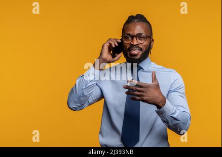 Eleganter Geschäftsmann in Brillen im Gespräch auf seinem Smartphone Stockfoto