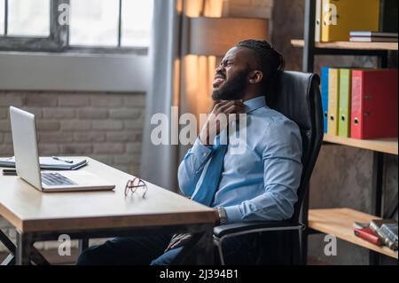 Büroangestellter mit Halsschmerzen Stockfoto