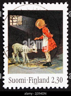 FINNLAND - UM 1993: Eine in Finnland gedruckte Briefmarke zeigt Mädchen mit Lamm aus dem Jahr 1936, Kunst von Martta Wendelin, um 1993 Stockfoto