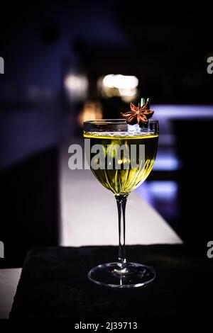 Eine vertikale Aufnahme eines klassischen Cocktails mit Anisdessin auf schwarzem Hintergrund Stockfoto