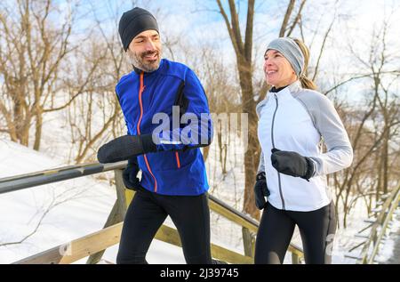 Reifes Paar im Winter läuft auf Treppen zusammen in der Natur Stockfoto