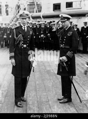 Ein Bild, das an Bord des Vierteldecks des bekannten Schlachtschiffs in Plymouth aufgenommen wurde und den Prinz von Wales (später König Edward VIII.) - rechts - zum Gruß und seinen Bruder, den Herzog von York, jetzt König George VI., zeigt Abgebildet war im Zusammenhang mit der Reise des Prinzen von Wale durch Japan und den Osten. 21. Juni 1922. (Foto von Reuterphoto). Stockfoto