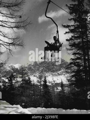 Erwartete Gesellschaft (Fünfte von sieben) -- der Sessellift bringt Sie über den Schnee und die Bäume zu Ihrem Ziel. Dieses hübsche Mädchen ist auf dem Weg zum Mount Druscie. 19. August 1955. (Foto von United Press). Stockfoto