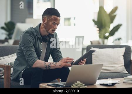 Lassen Sie sich nicht von Kritik ablenken. Aufnahme eines jungen Geschäftsmanns, der bei der Arbeit ein Tablet benutzt. Stockfoto