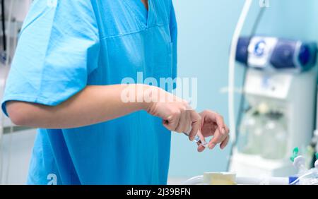 Die Hand des Arztes zieht Medizin aus einer Ampulle in eine medizinische Spritze. Selektiver Fokus. Spritze mit Impfstoff in der Hand des Arztes. Weichfokus. Injektion. Das Konzept der Impfung. Stockfoto