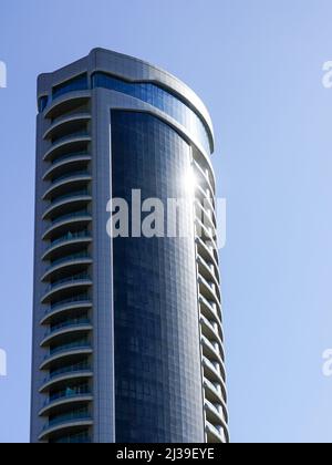 Fragment der Fassade eines abstrakten hohen Bürogebäudes vor blauem Himmel Stockfoto