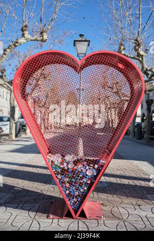 Herzförmiger Auffangbehälter für Flaschenverschlüsse aus Kunststoff. In San Martín de Valdeiglesias, Madrid, Spanien werden die Verschlüsse zum Recycling gesammelt. Stockfoto