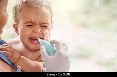 Wir müssen diese Passagen freimachen. Aufnahme eines Arztes, der ein Schnittool verwendet, um einen Schleim eines Babys zu lindern. Stockfoto