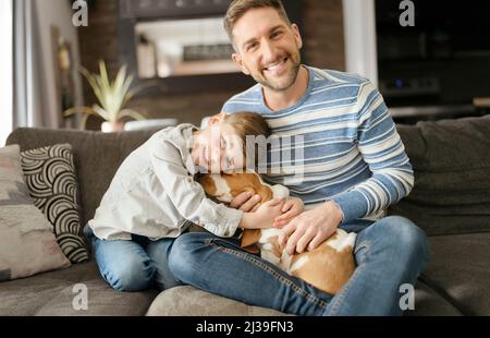 Vater oder Pate, die Spaß im Wohnzimmer zu Hause mit Basset Hund Stockfoto