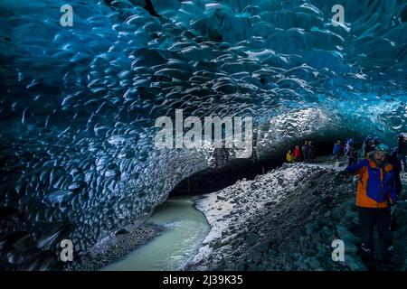JOKULSARLON, ISLAND - NOVEMBER 18 2021: Touristen erkunden das Innere einer spektakulären Eishöhle unter dem Vatnajökull-Gletscher im Süden Islands Stockfoto