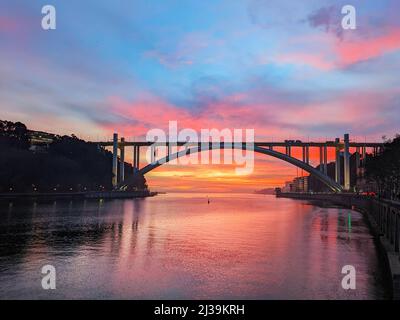 Malerischer, farbenfroher Sonnenuntergang über der Brücke von Arrabida, Stadtbild von Porto, Portugal Stockfoto