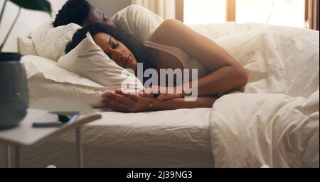 Schlafe mit meinem Schatz. Eine kurze Aufnahme eines jungen attraktiven Paares, das zu Hause im Bett schläft. Stockfoto