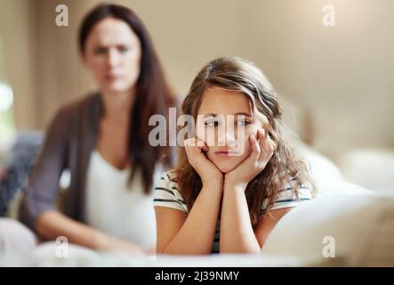 Ignorieren Sie mich nicht, wenn ich spreche. Kurzer Schuss eines jungen Mädchens, das von ihrer Mutter zu Hause getagt wurde. Stockfoto