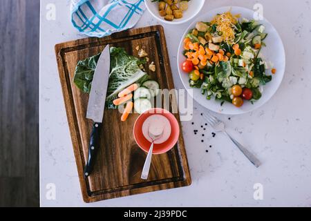 Frischer und gesunder grüner gemischter Salat, zubereitet in der weißen Küche Stockfoto