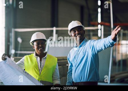 Der sichere Weg ist der intelligente Weg. Aufnahme von zwei Bauherren, die sich auf einer Baustelle treffen. Stockfoto