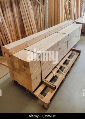 Gestapelte Holzbretter in einer holzverarbeitenden Industrie. Stapel mit Kiefernholz. Gefaltete kantige Platte. Holzernterei. Holz für den Bau, erhöhen Stockfoto
