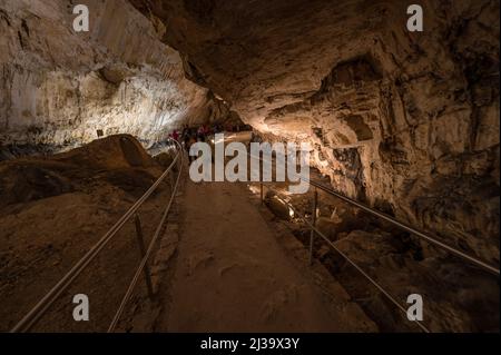 Eine Gruppe von Touristen, die in der Freiheitshöhle Demanovska, Slowakei, spazieren gehen Stockfoto