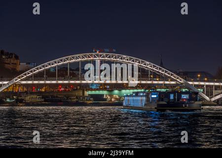 Erleuchtete Fußgängerbrücke bei Nacht in Paris seine und Touristen Kreuzfahrten Stockfoto