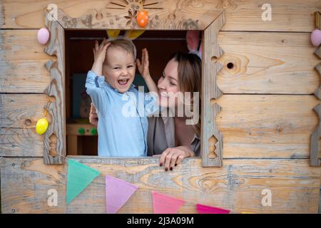 Mutter und Sohn in Hasenohren feiern ostern, spielen im Spielhaus. Frohe Ostern. Stockfoto