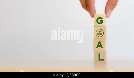 Nettonull Ziel und Strategiekonzept. Dekarbonisierung, kohlenstoffarme Wirtschaft für nachhaltige Entwicklung. Von Hand vertikale Holzwürfel mit „ZIEL“-Text A setzen Stockfoto