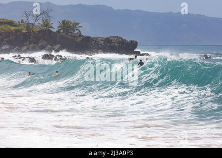 Die große Welle an der Waimea Bay überwältigt Schwimmer und Surfer Stockfoto