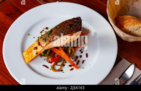 Gebackener Lachs mit sautiertem Gemüse Stockfoto