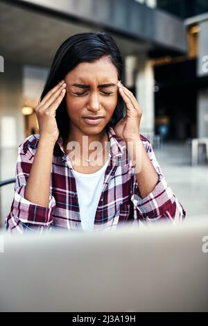 Ich denke, es ist an der Zeit, dass ich eine Pause mache. Ausgeschnittene Aufnahme einer jungen Studentin, die draußen auf dem Campus Kopfschmerzen hat. Stockfoto