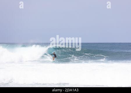 Surfer fangen eine Welle an der Banzai Pipeline in Hawaii Stockfoto