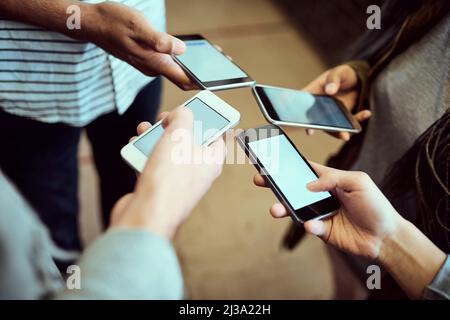 Kabellos arbeiten. In einem Korridor auf dem Campus stehend, wurde eine Gruppe von nicht erkennbaren Universitätsstudenten aufgenommen, die ihr Mobiltelefon benutzten. Stockfoto