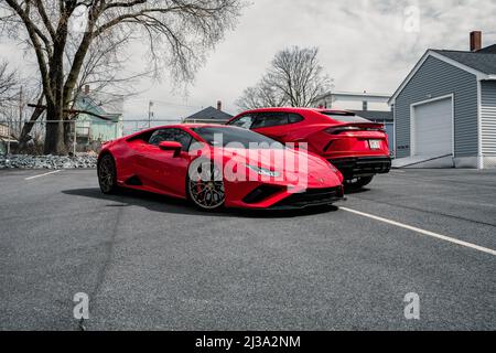 Eine schöne Aufnahme von zwei roten Lamborghini Autos Urus und Huracan geparkt auf der Straße tagsüber gegen bewölkten Himmel in Boston, USA Stockfoto