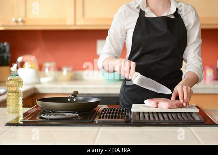 Der Küchenchef bereitet frische Schweinefleisch Steaks in der Küche, Hausmannskost-Menü. Kulinarische Rezepte. Restaurant-Menü. Stockfoto