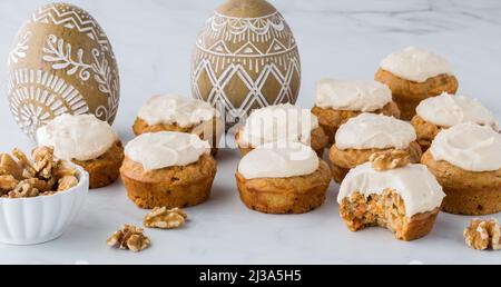 Mehrere hausgemachte Karotten-Kuchen-Muffins mit einem Bissen aus dem davor. Stockfoto